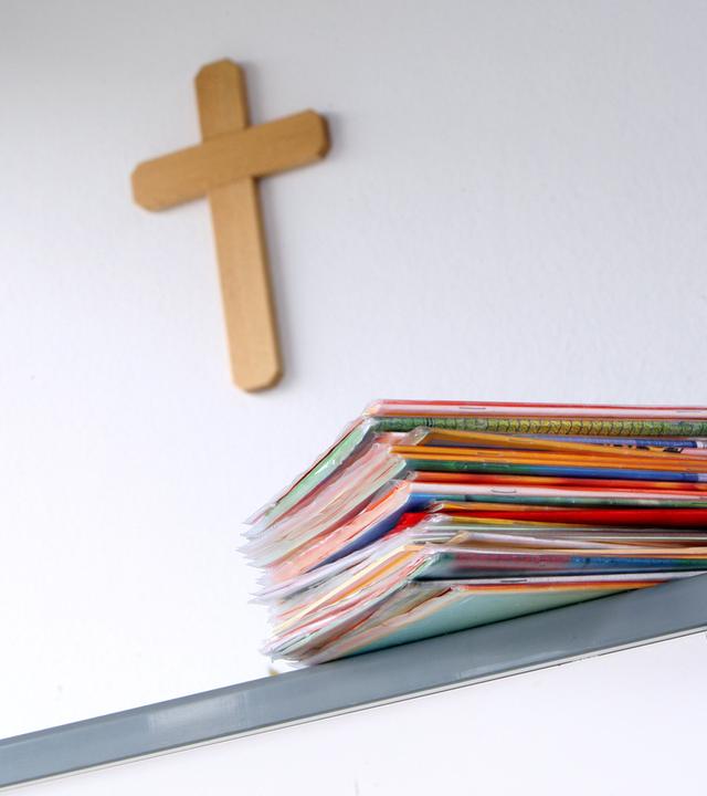 Ein Kruzifix hängt am 27.04.2010 in einem Klassenzimmer einer Grundschule in Kaufbeuren, Schwaben, hinter dem Lehrerpult mit Schulheften. 
