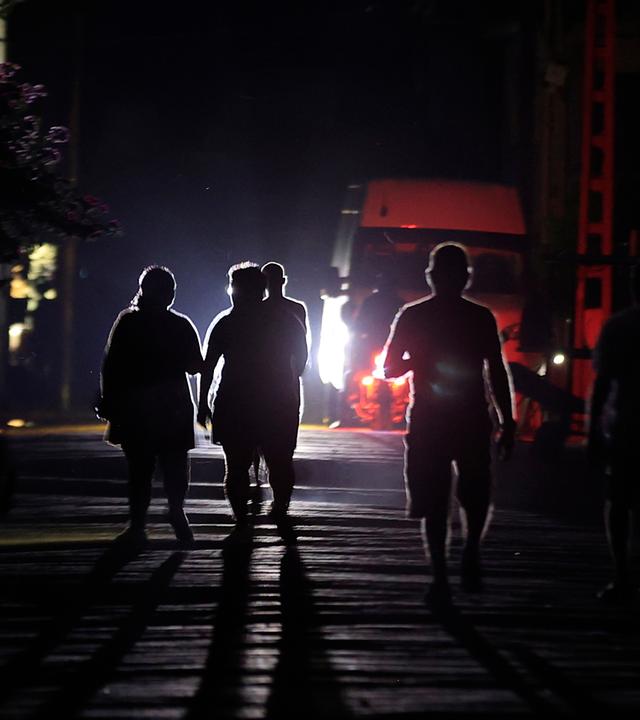 Menschen gehen während eines Stromausfalls in Havanna, Kuba, eine Straße entlang – 25. Mai 2026.
