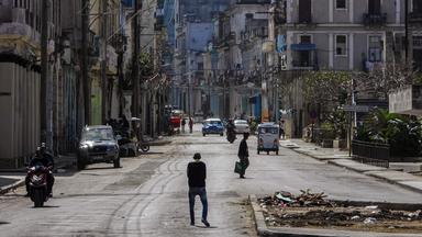 Menschen gehen am 8. Februar 2026 eine ruhige Straße in Havanna entlang.
