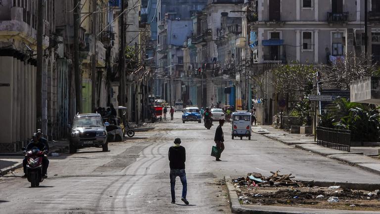 Menschen gehen am 8. Februar 2026 eine ruhige Straße in Havanna entlang.