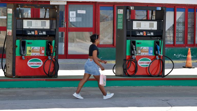 Kuba: Eine Frau an einer leeren Tankstelle in Havana. 