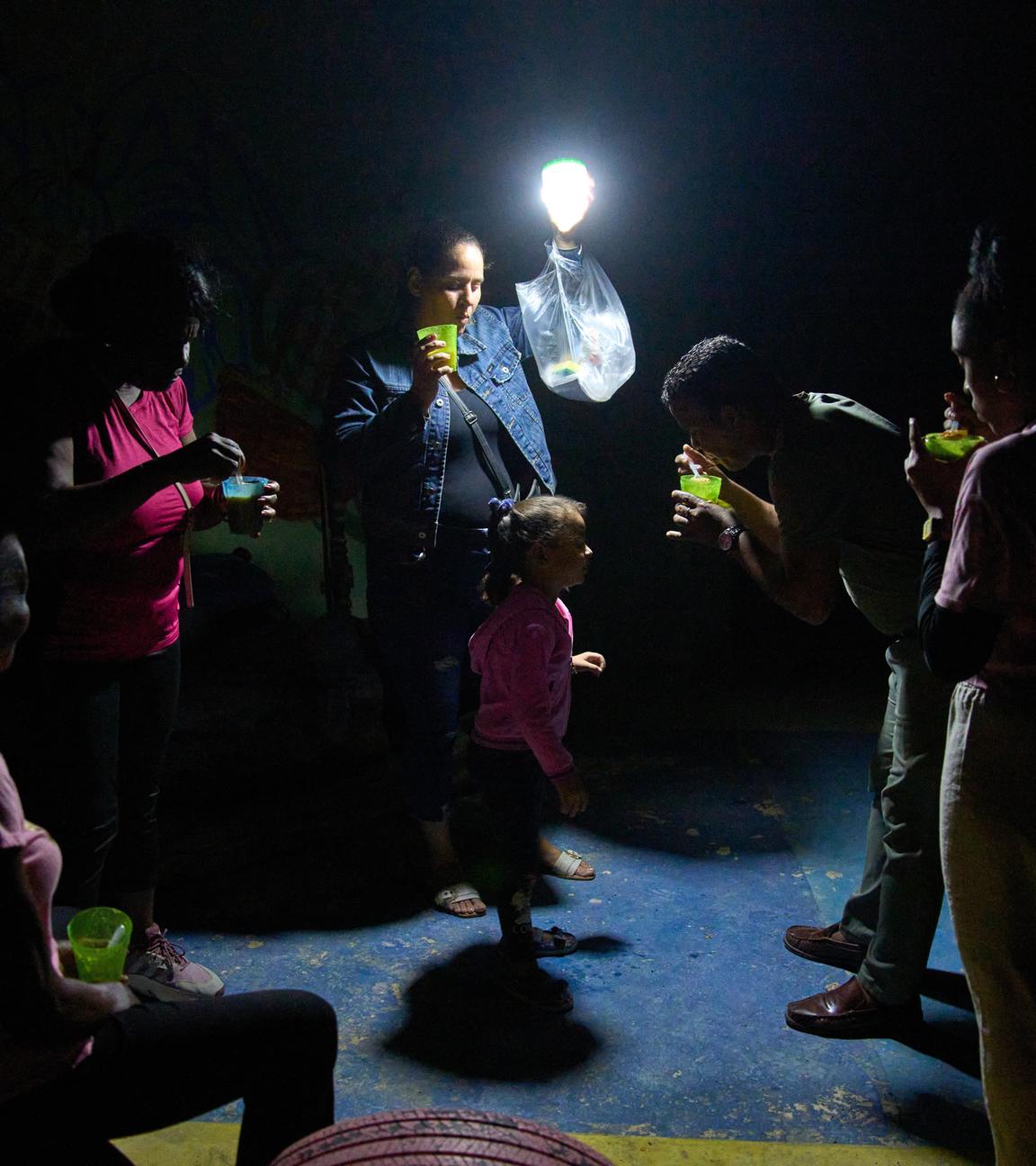 Ein Mann gibt einem Mädchen auf der Straße während eines Stromausfalls in Havanna einen Löffel Suppe.
