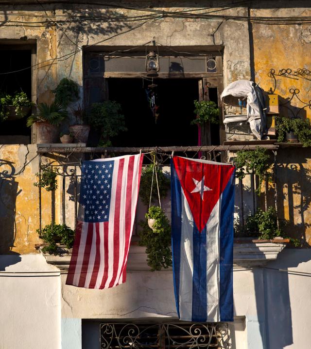Eine kubanische und eine US-amerikanische Flagge hängen nebeneinander an einem Balkon.
