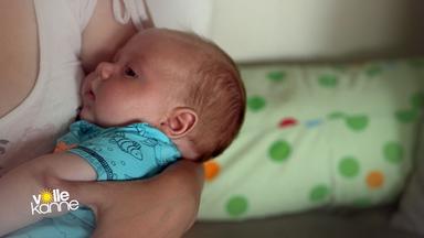 Frau hält ein Baby auf dem Arm.
