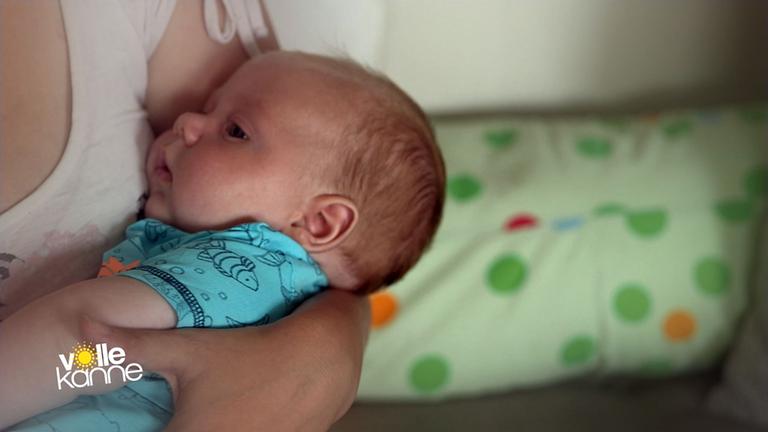 Frau hält ein Baby auf dem Arm.