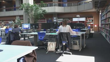 Bibliothek in der Menschen an Schreibtischen sitzen 