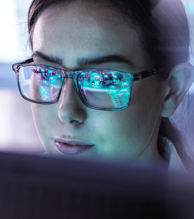 Eine junge Frau arbeitet an einem Computerbildschirm.