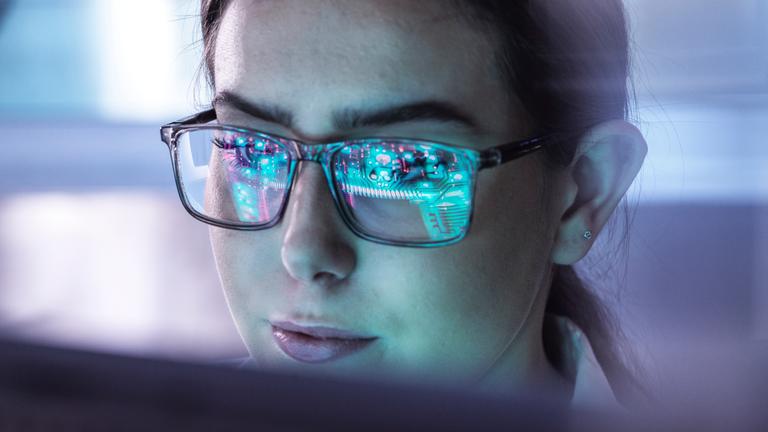 Eine junge Frau arbeitet an einem Computerbildschirm.