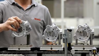 Ein Mitarbeiter von Bosch bringt bei der Produktion von Dieseleinspritzpumpen ein Bauteil in Position. 