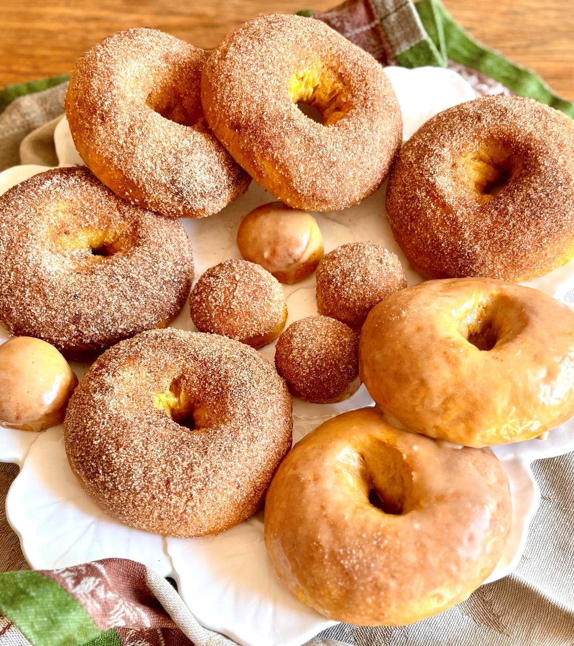 Mehrere Kürbis-Donuts liegen auf einem Teller