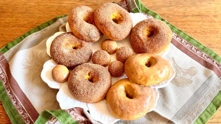 Mehrere Kürbis-Donuts liegen auf einem Teller