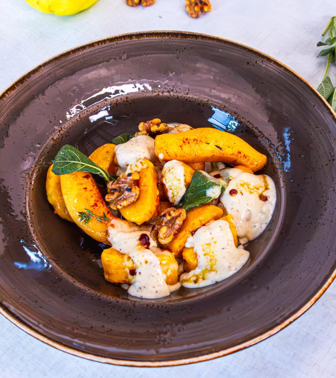 Ein tiefer Teller mit Kürbisgnocchi und Quitten