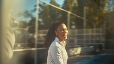 Yemisi Mabry steht lachend vor einer Glas-Wand.