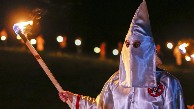 Mitglied des Ku Klux Klan mit brennender Fackel