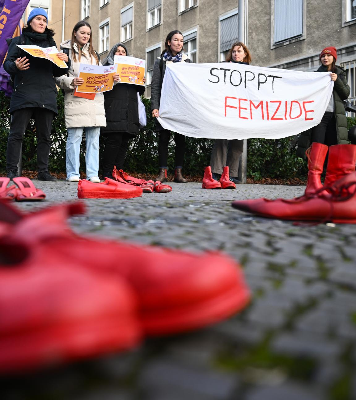 Berlin: Teilnehmerinnen halten während des Hissens der Anti-Gewalt-Fahne anlässlich des Internationalen Tags für die Beseitigung von Gewalt gegen Frauen am Rathaus Tiergarten