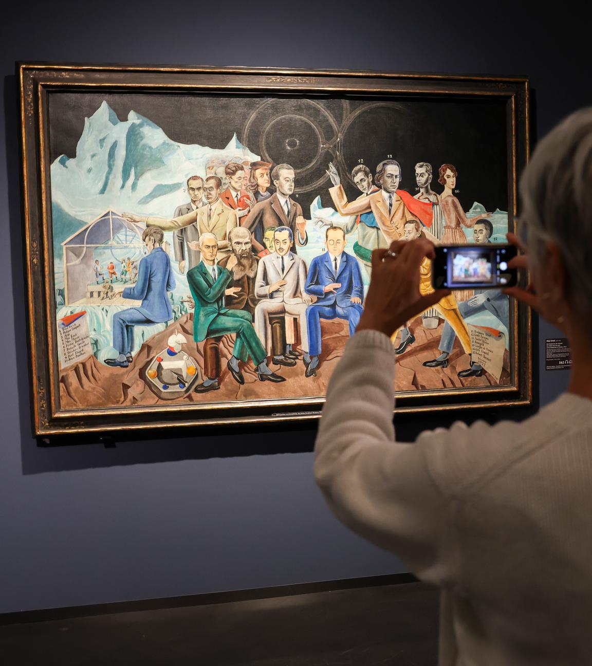 Eine Besucherin fotografiert das Bild "Das Rendezvous der Freunde" (1922) von Max Ernst beim Eröffnungsrundgang in der Hamburger Kunsthalle in der Ausstellung "Rendezvous der Träume - Surrealismus und deutsche Romantik".