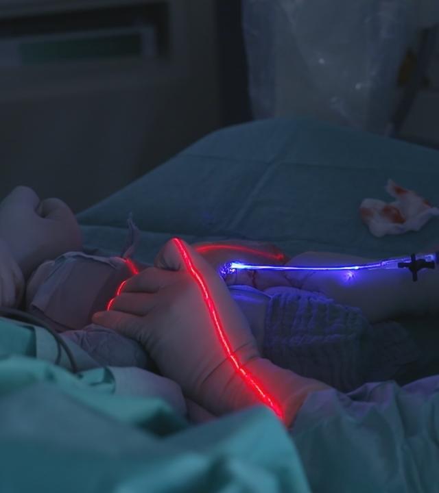 Arm bei einer Operation mit blauem Licht