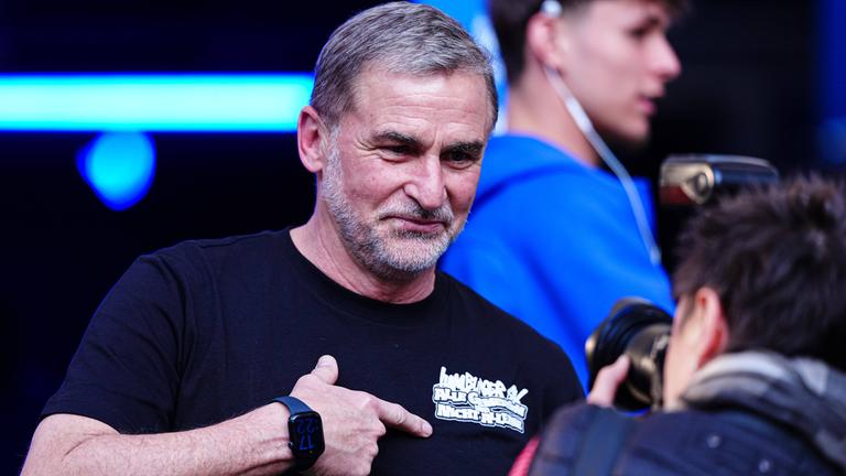 Stefan Kuntz deutet auf den Schriftzug auf seinem T-Shirt