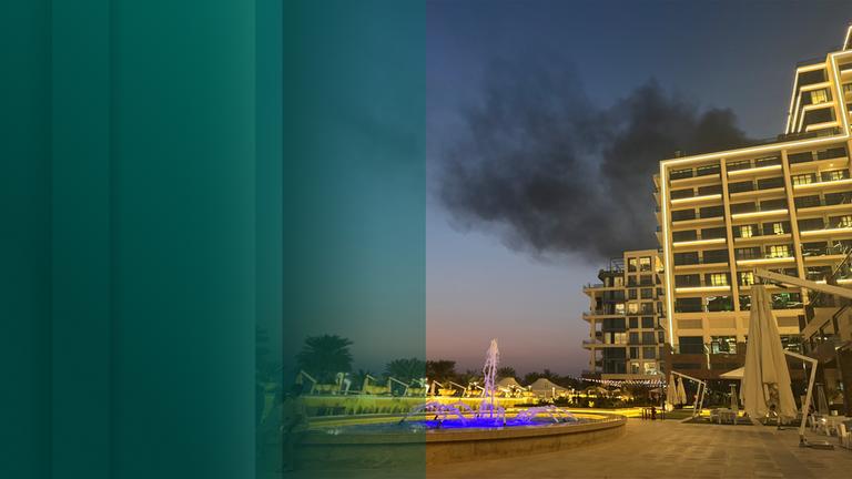 Hotel in Dubai mit Rauchwolke im Hintergrund