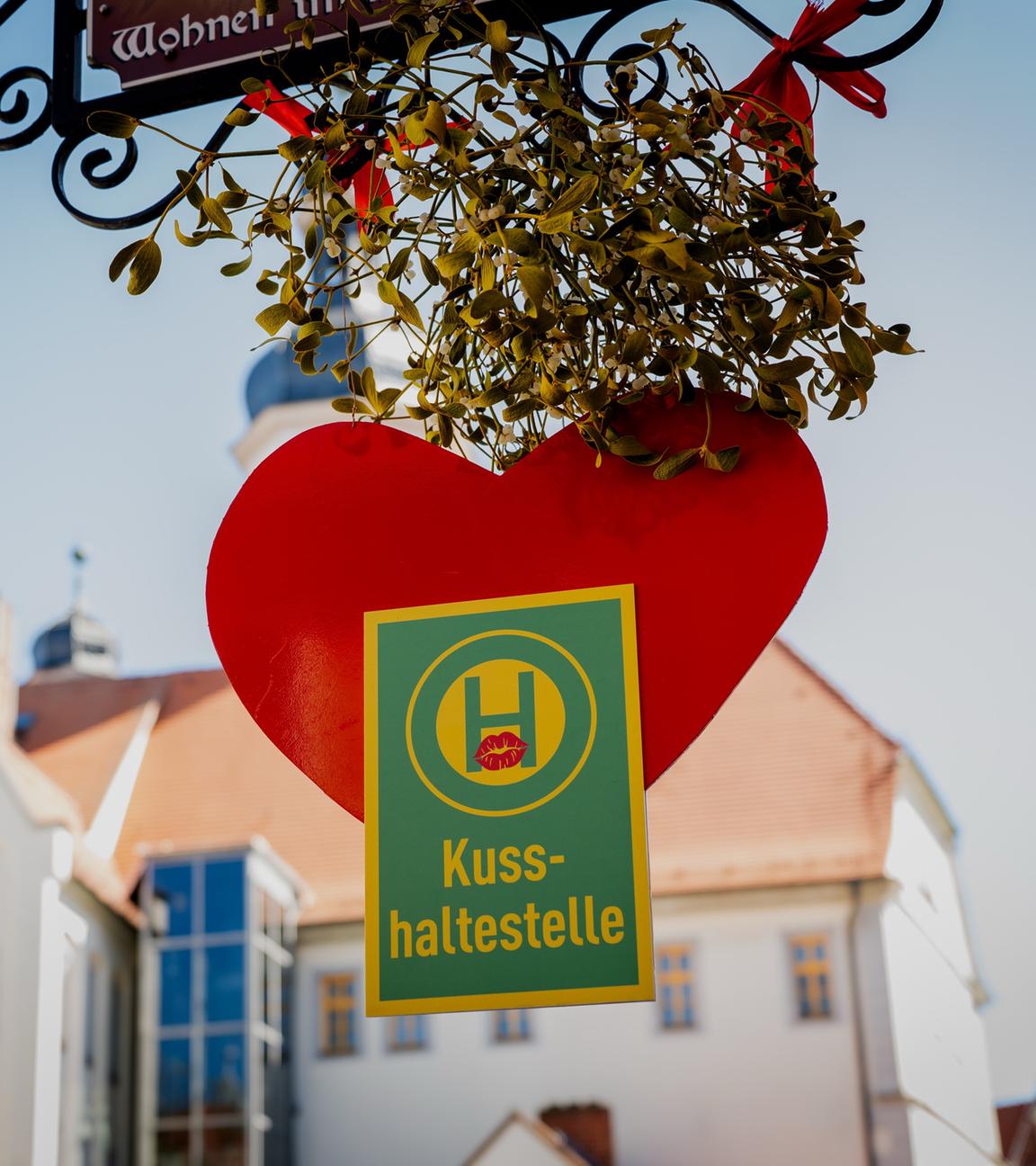 Eine Haltestelle zum Küssen in Eisenberg mit einem roten Herz und grünem Mistelzweig.