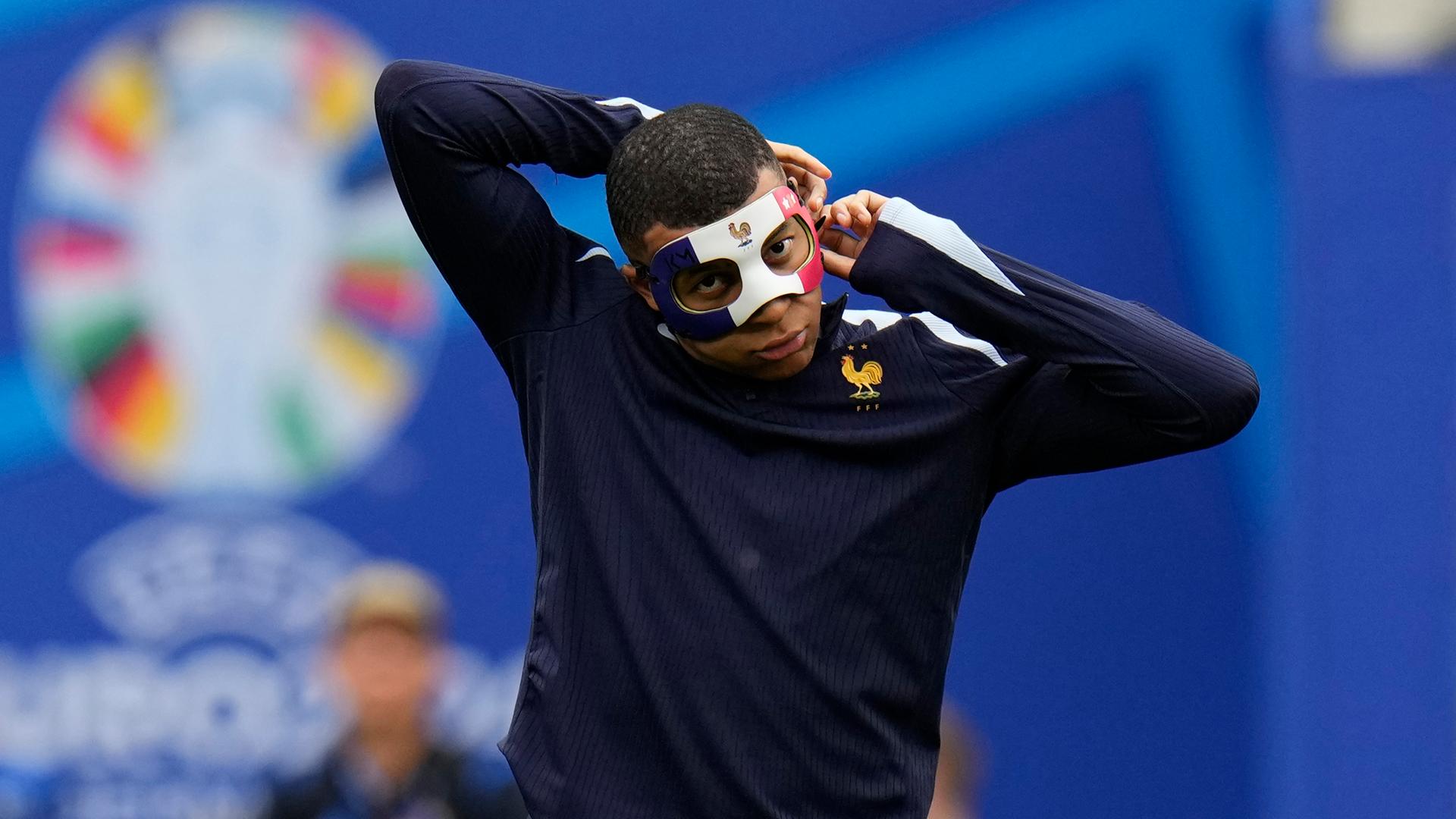 Kylian Mbappe passt seine Gesichtsmaske während einer Trainingseinheit in Leipzig, am 20.06.2024, an.