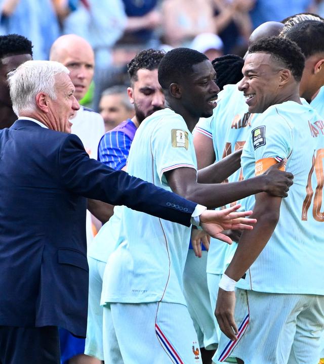 Fußballspieler Demeble und Kylian Mbappé lachend auf dem Fußballfeld