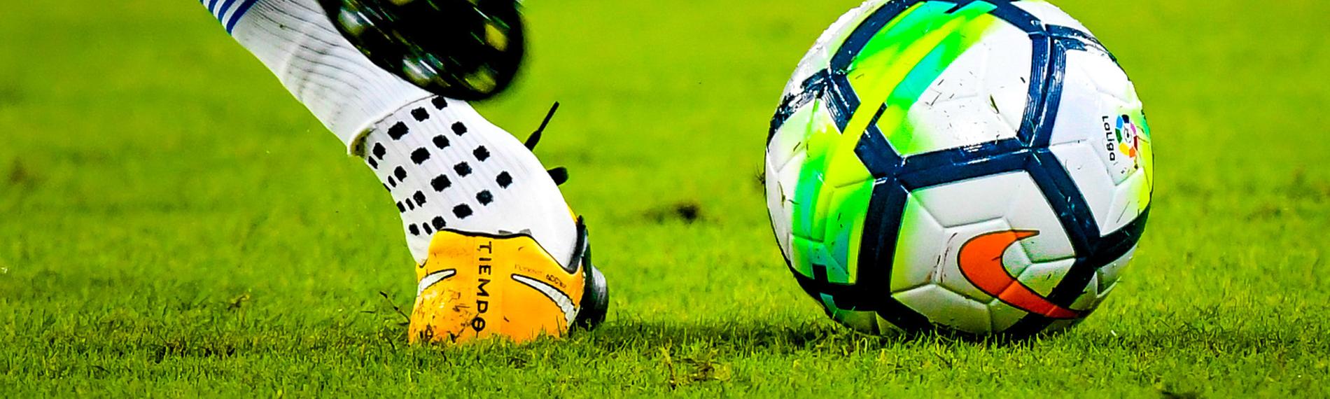 Ein spanischer Fußballspieler holt im Match zwischen den Vereinen Sevilla und Espanyol zum Tritt gegen den Ball aus. 