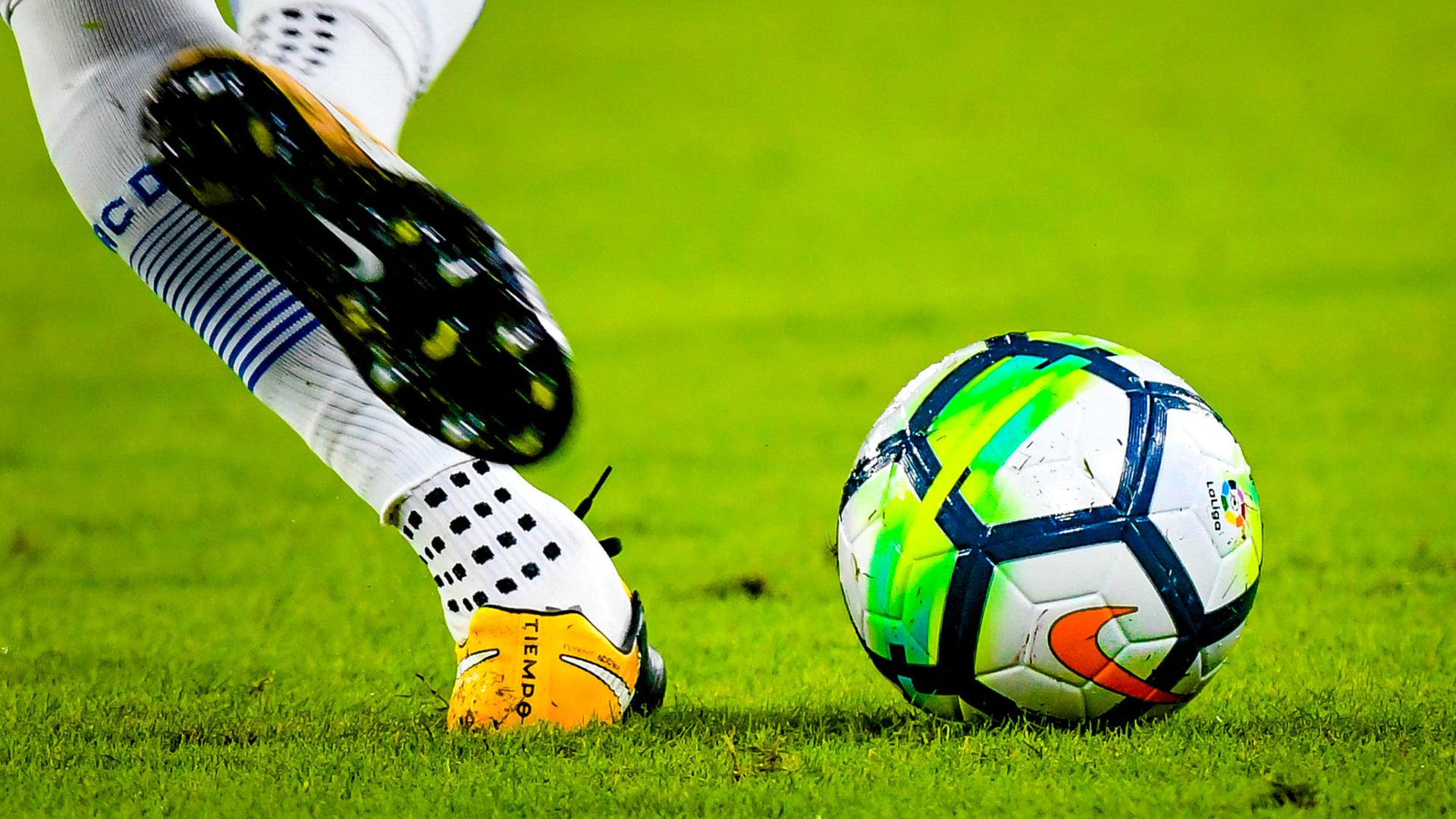 Ein spanischer Fußballspieler holt im Match zwischen den Vereinen Sevilla und Espanyol zum Tritt gegen den Ball aus. 