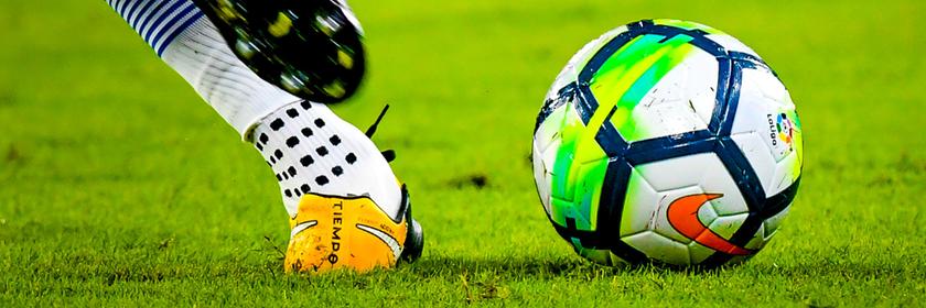 Ein spanischer Fußballspieler holt im Match zwischen den Vereinen Sevilla und Espanyol zum Tritt gegen den Ball aus. 