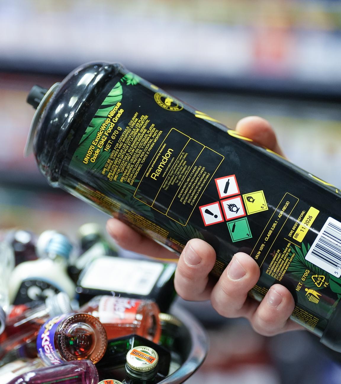  Ein Mitarbeiter hält eine Dose Lachgas am Tresen eines Hamburger Kiosks in der Hand.