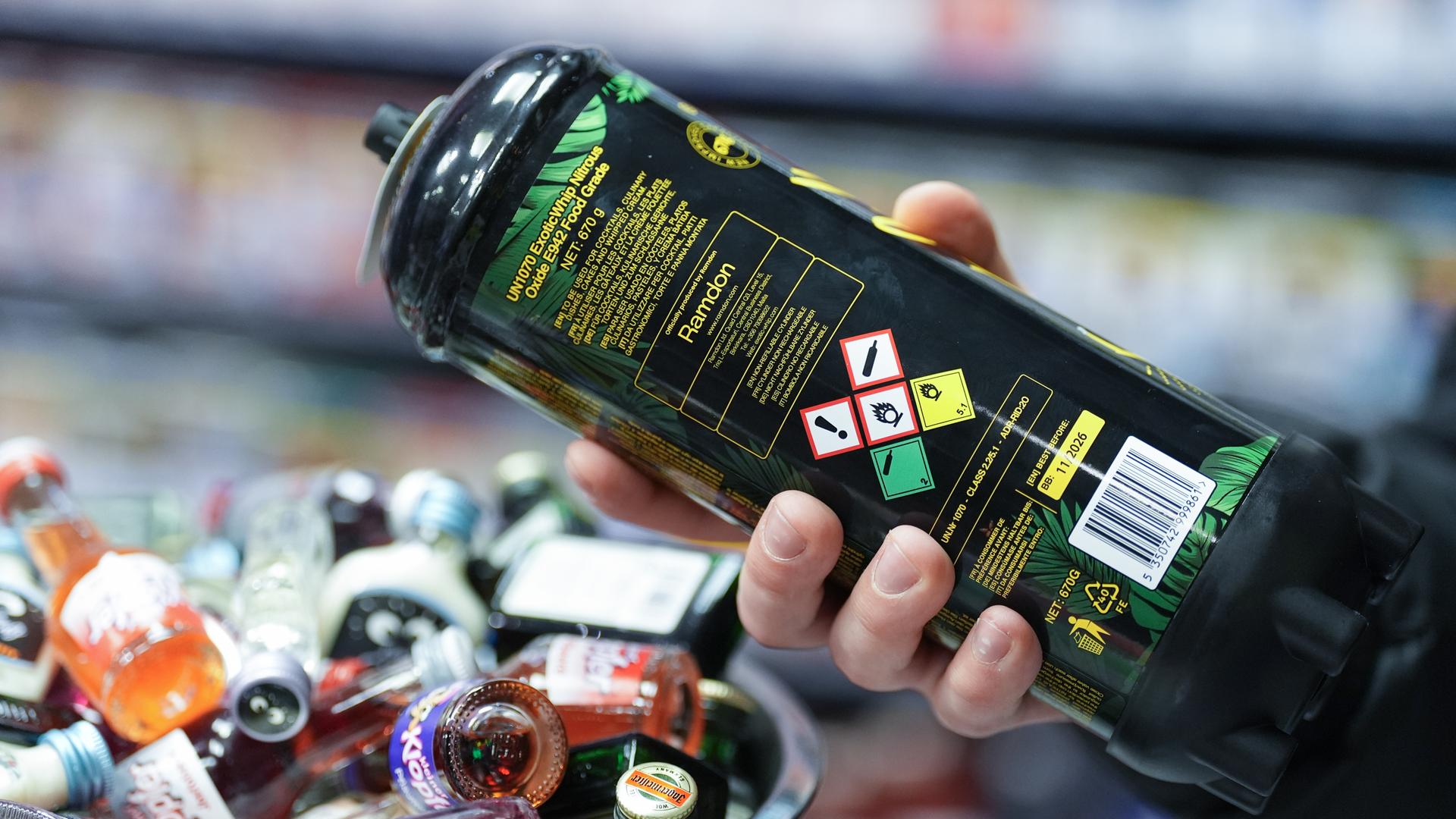  Ein Mitarbeiter hält eine Dose Lachgas am Tresen eines Hamburger Kiosks in der Hand.