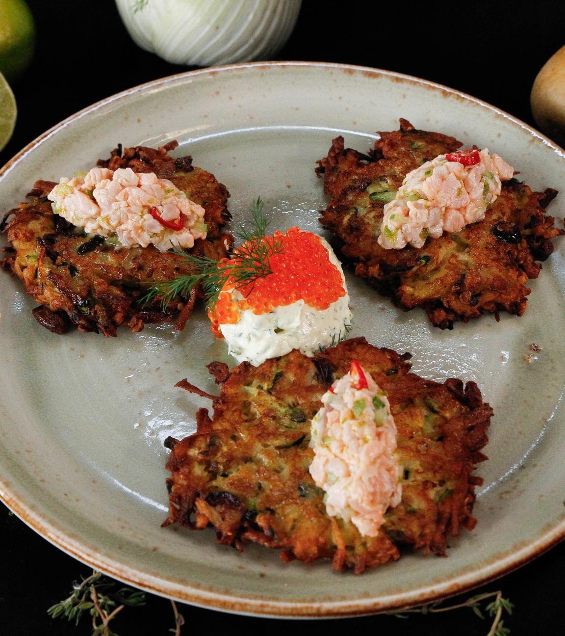 Lachsforellen-Fenchel-Tatar auf sommerlichen Kartoffelpuffern angerichtet auf einem Teller