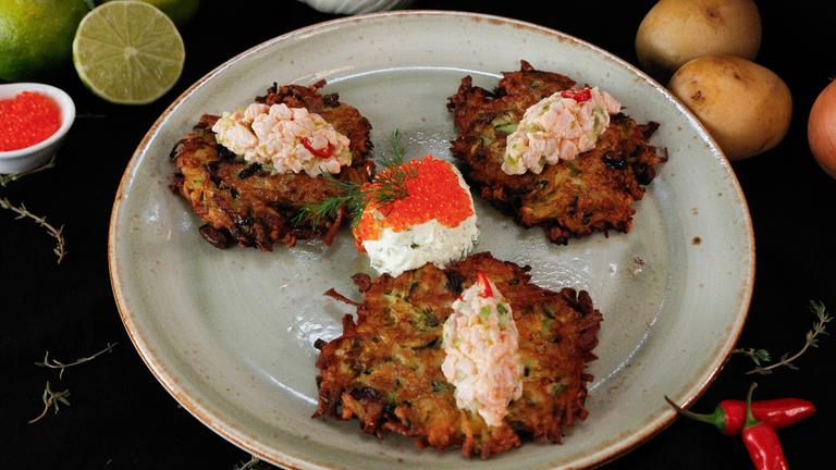 Lachsforellen-Fenchel-Tatar auf sommerlichen Kartoffelpuffern angerichtet auf einem Teller
