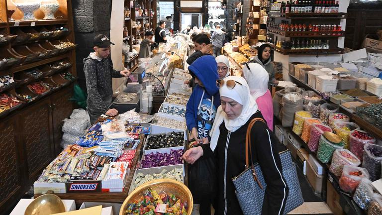 Käufer stöbern am 29.03.2025 in einem Geschäft auf dem überdachten Hamidiya-Markt in Damaskus nach Süßigkeiten
