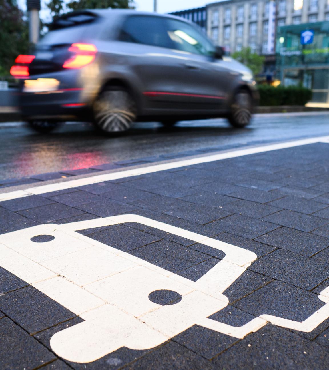 Ein Symbol markiert einen Parkplatz an einer Ladesäule für Elektroautos.