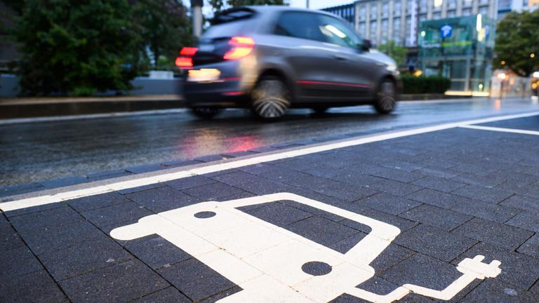 Ein Symbol markiert einen Parkplatz an einer Ladesäule für Elektroautos.