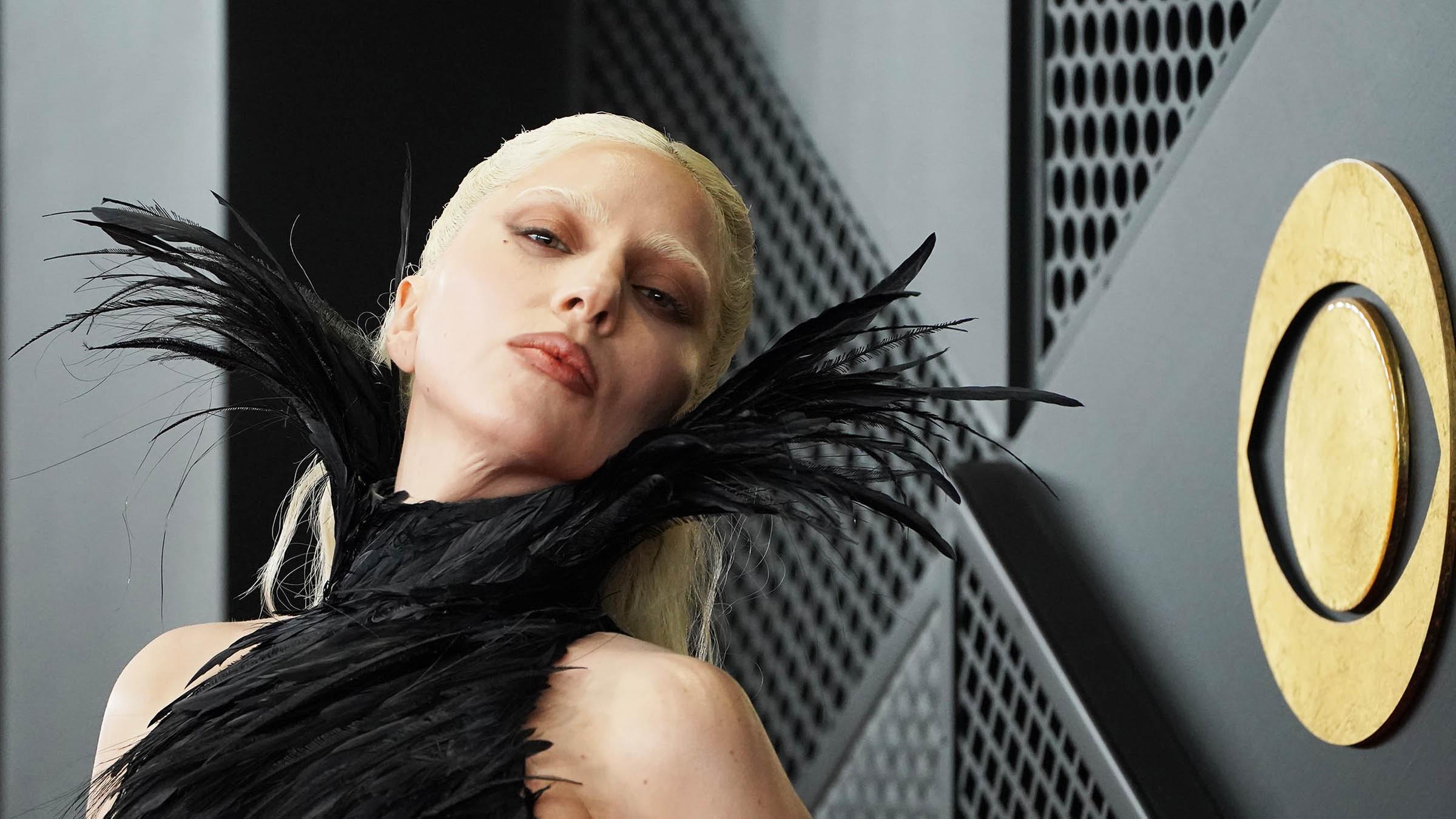 Lady Gaga in schwarzem, hochgeschlossenen Federkleid auf dem Roten Teppich bei den Grammys.