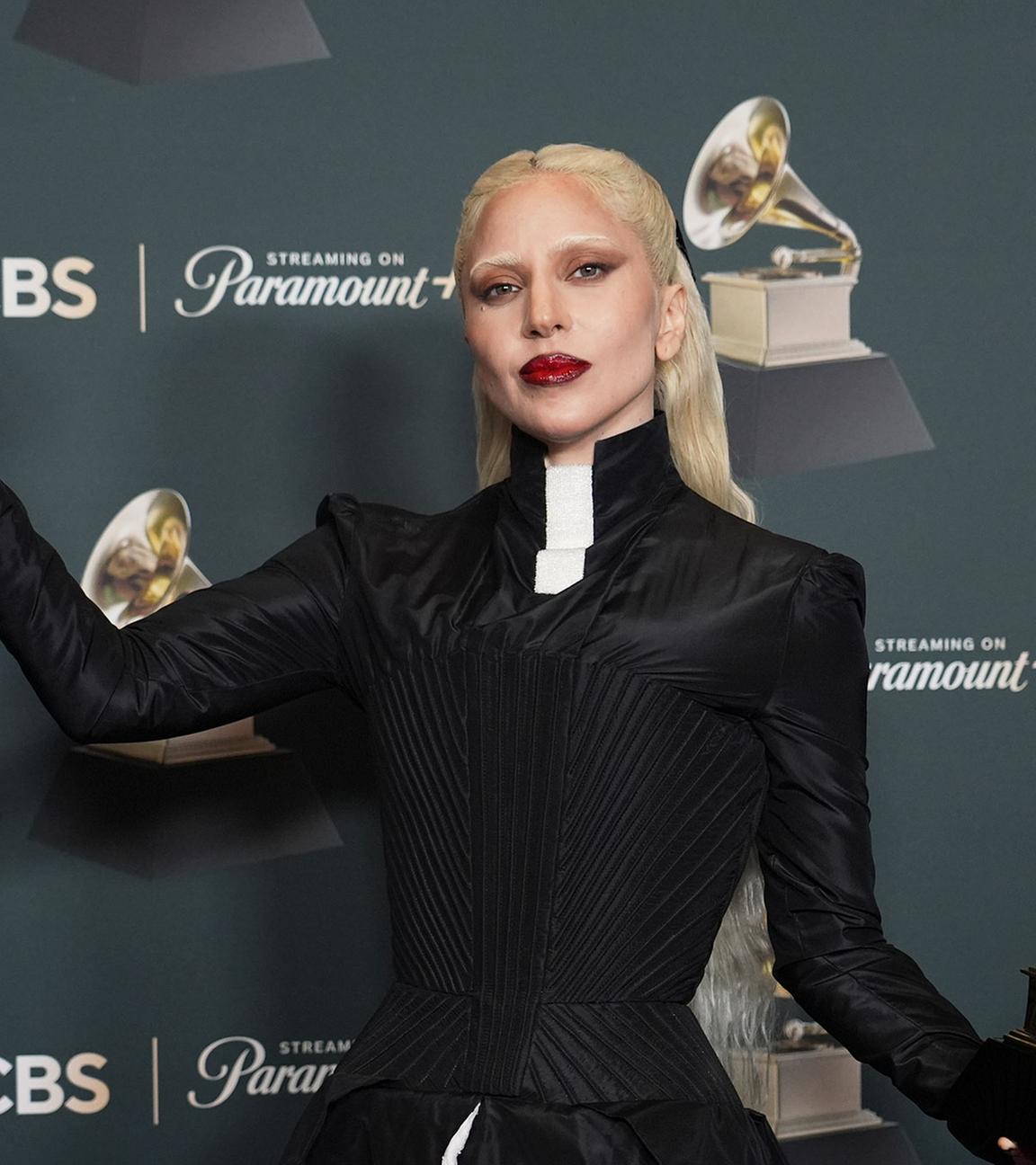 Lady Gaga ist während einer Preisverleihung zu sehen. Sie hält zwei goldene Awards in den Händen.