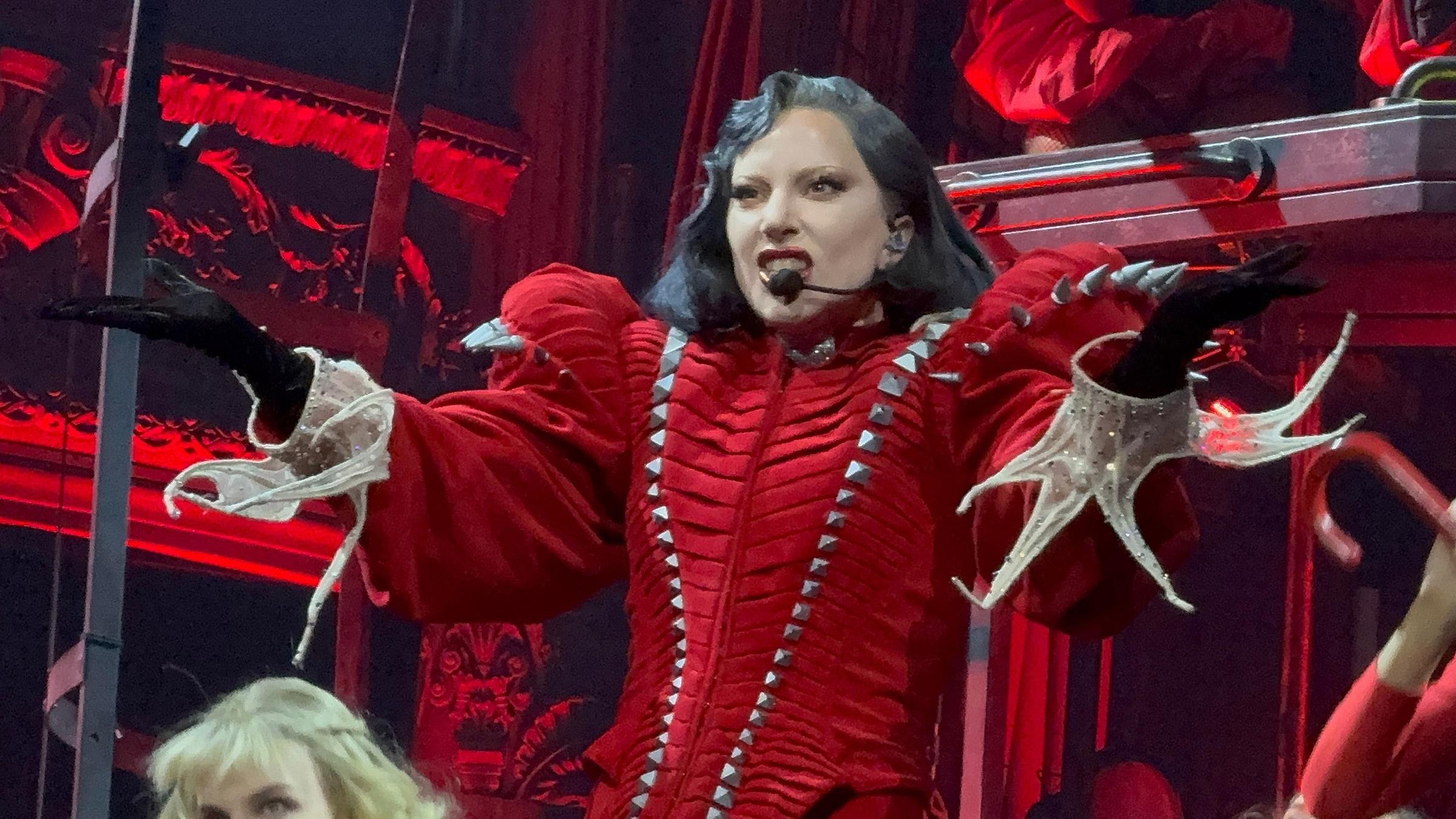 Die Sängerin Lady Gaga im roten Outfit mit Nieten und Schulterpolstern bei einem Auftritt.