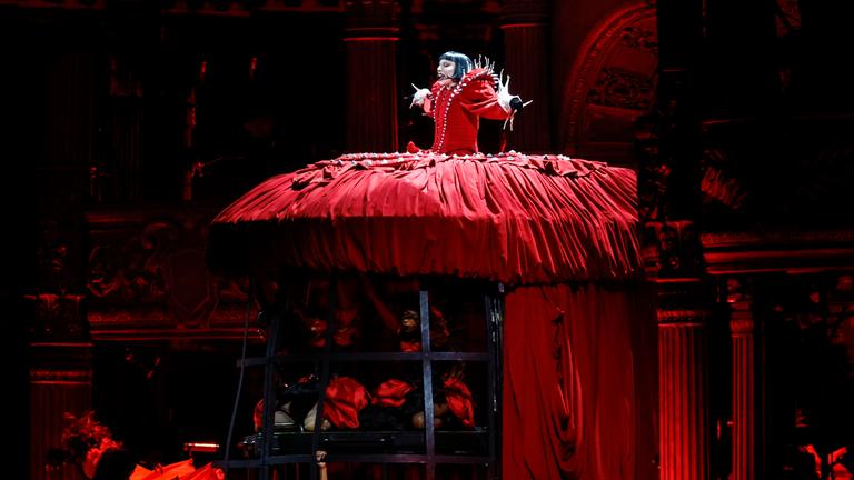 Lady Gaga Performance in Rio de Janeiro - sie steht in einem Roten langen Kleid auf einer erhöhten Bühne und singt