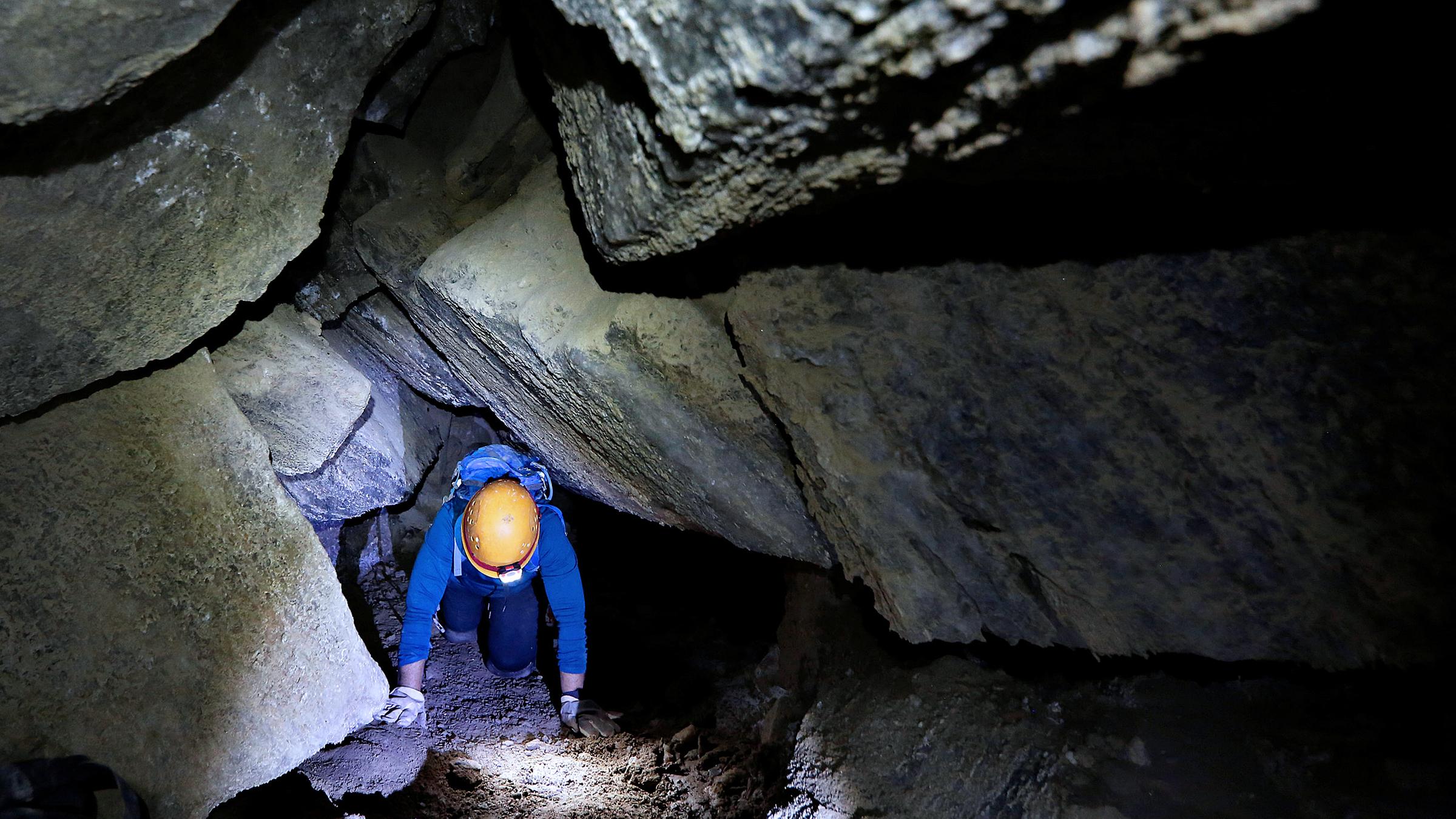 Eine Frau auf allen Vieren kriechend in der Malcham-Höhle, Israel, aufgenommen am 27.03.2019