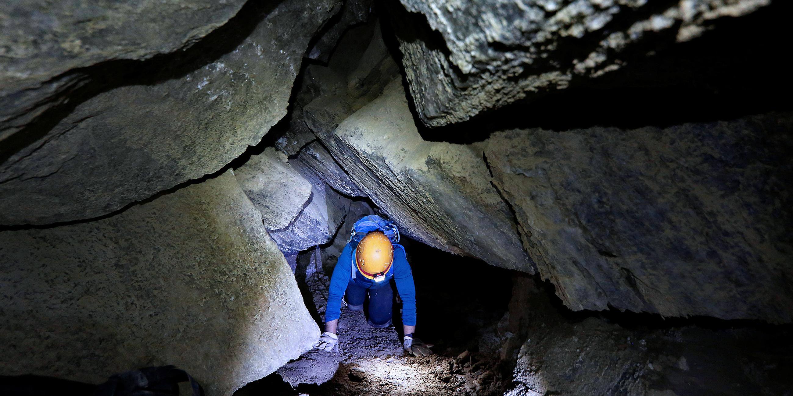 Eine Frau auf allen Vieren kriechend in der Malcham-Höhle, Israel, aufgenommen am 27.03.2019