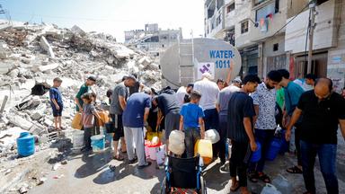 Wasserverteilung in Gaza-Stadt. Im Hintergrund sind Trümmer