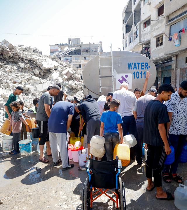 Wasserverteilung in Gaza-Stadt. Im Hintergrund sind Trümmer