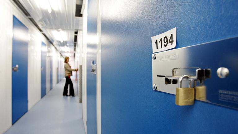 Ein Schloss hängt an einer Tür eines Lagerraumes.