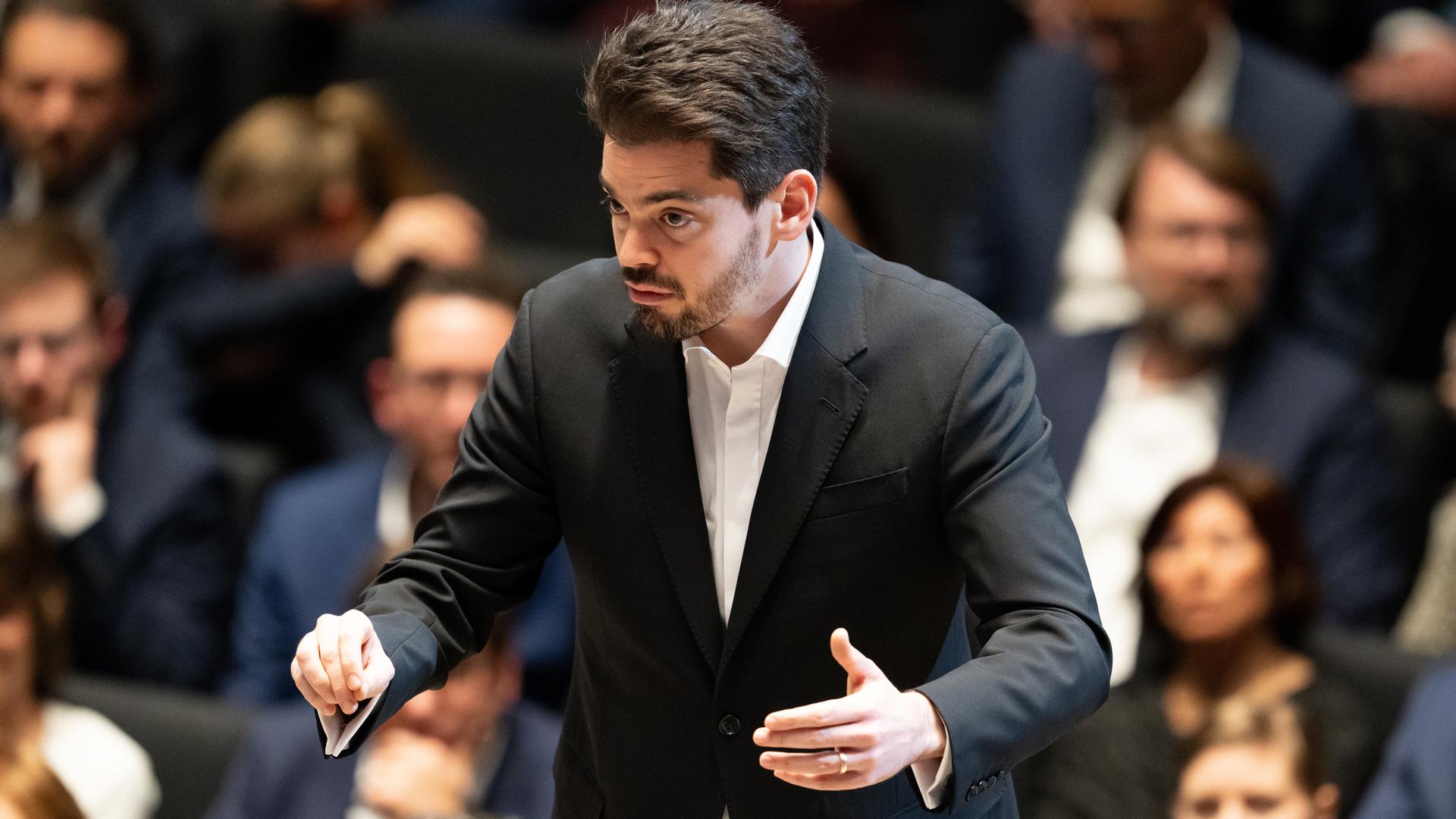 Lahav Shani steht nach der Verleihung der Goldenen Ehrenmünze der Stadt München an Dirigent Mehta auf der Bühne im Januar 2024.