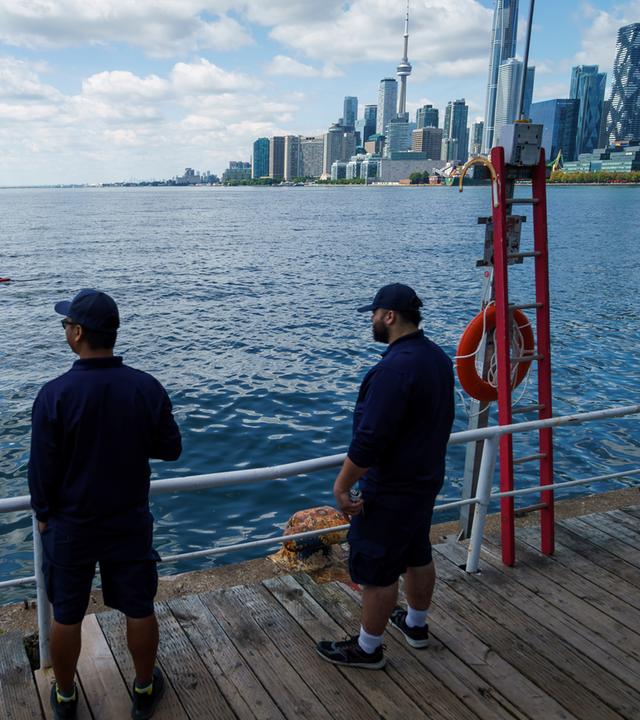 Menschen blicken vom Hafen in Toronto über Lake Ontario