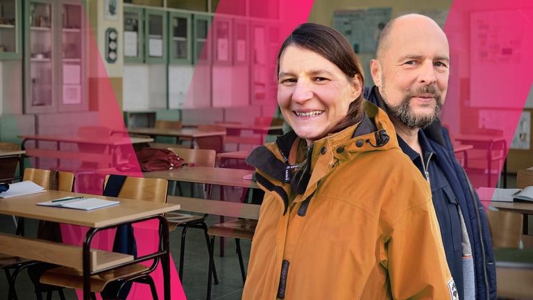 Eine junge Frau und ein junger Mann stehen in einem Klassenzimmer