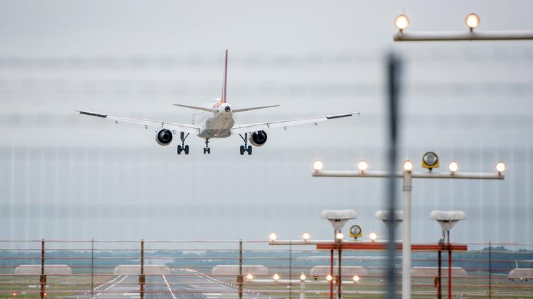 Ein Flugzeug landet am Helmut-Schmidt-Airport (Aufnahme durch einen Zaun). 