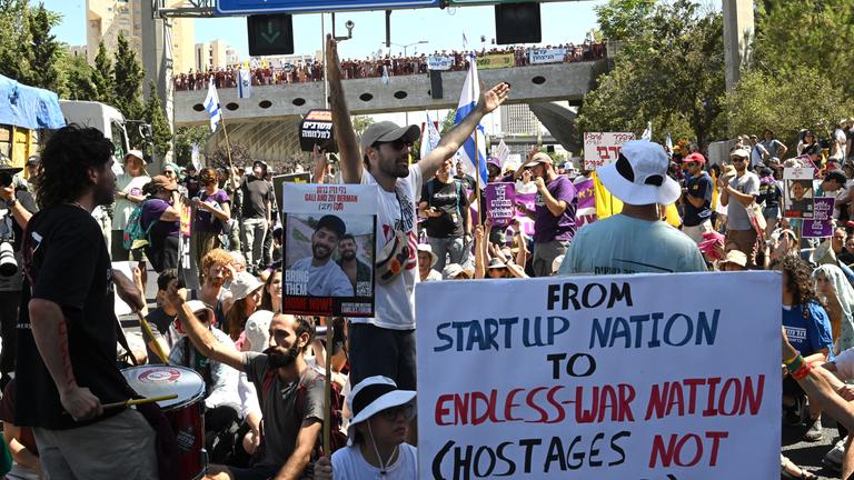 Familien und Unterstützer von Israelis, die von der Hamas in Gaza als Geiseln gehalten werden, blockieren eine wichtige Autobahn in Jerusalem während eines landesweiten Proteststreiks.